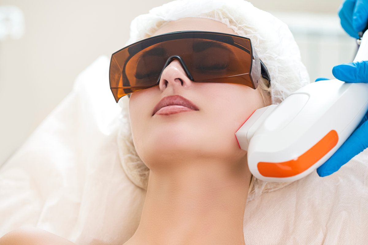 Young Caucasian Winsome Woman Getting IPL Laser and Ultrasound Facial Treatment in Modern Medical Spa Center As Skin Rejuvenation.Horizontal image